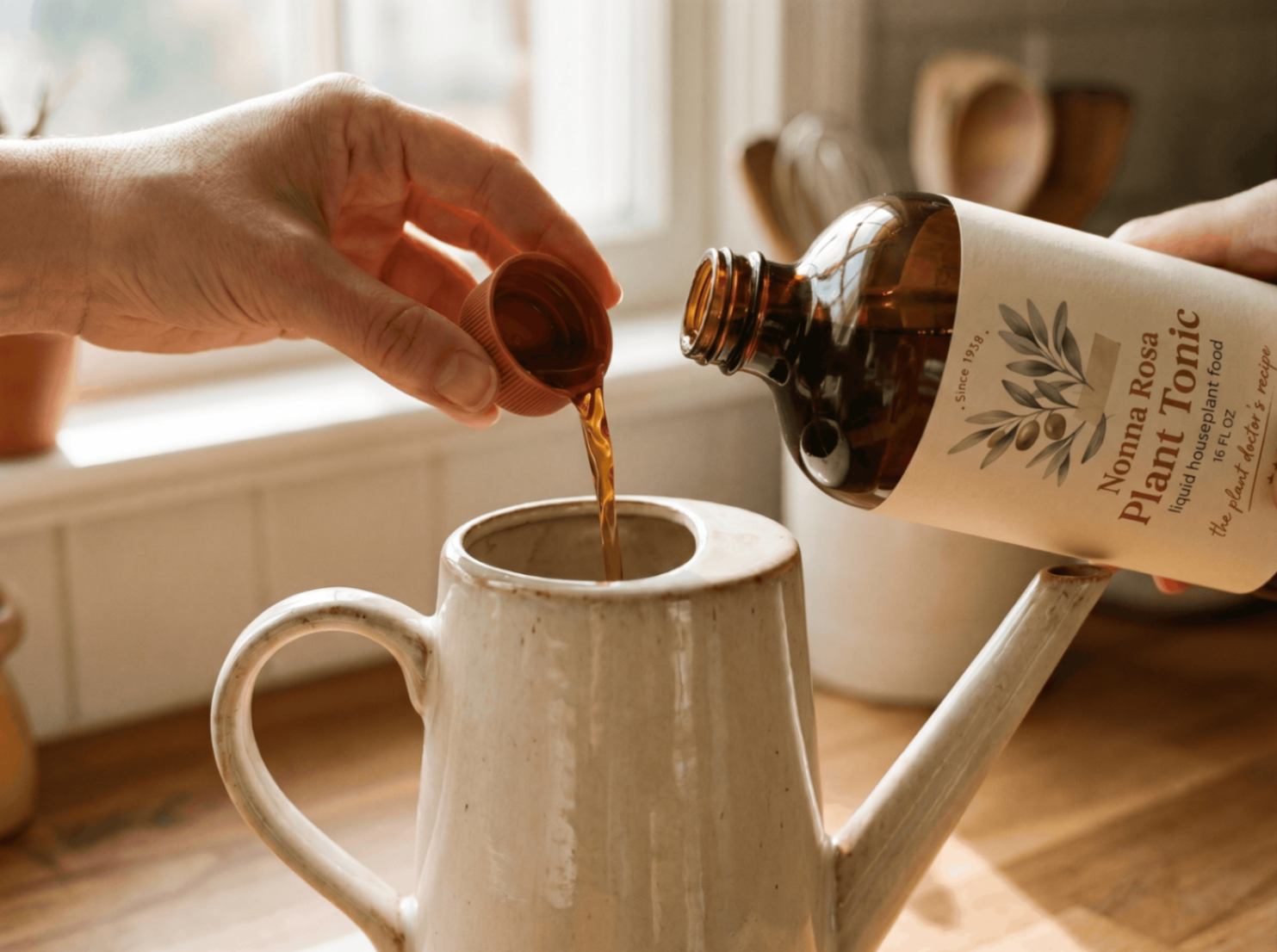 Nonna Rosa Plant Tonic being poured by the cap into a white watering can